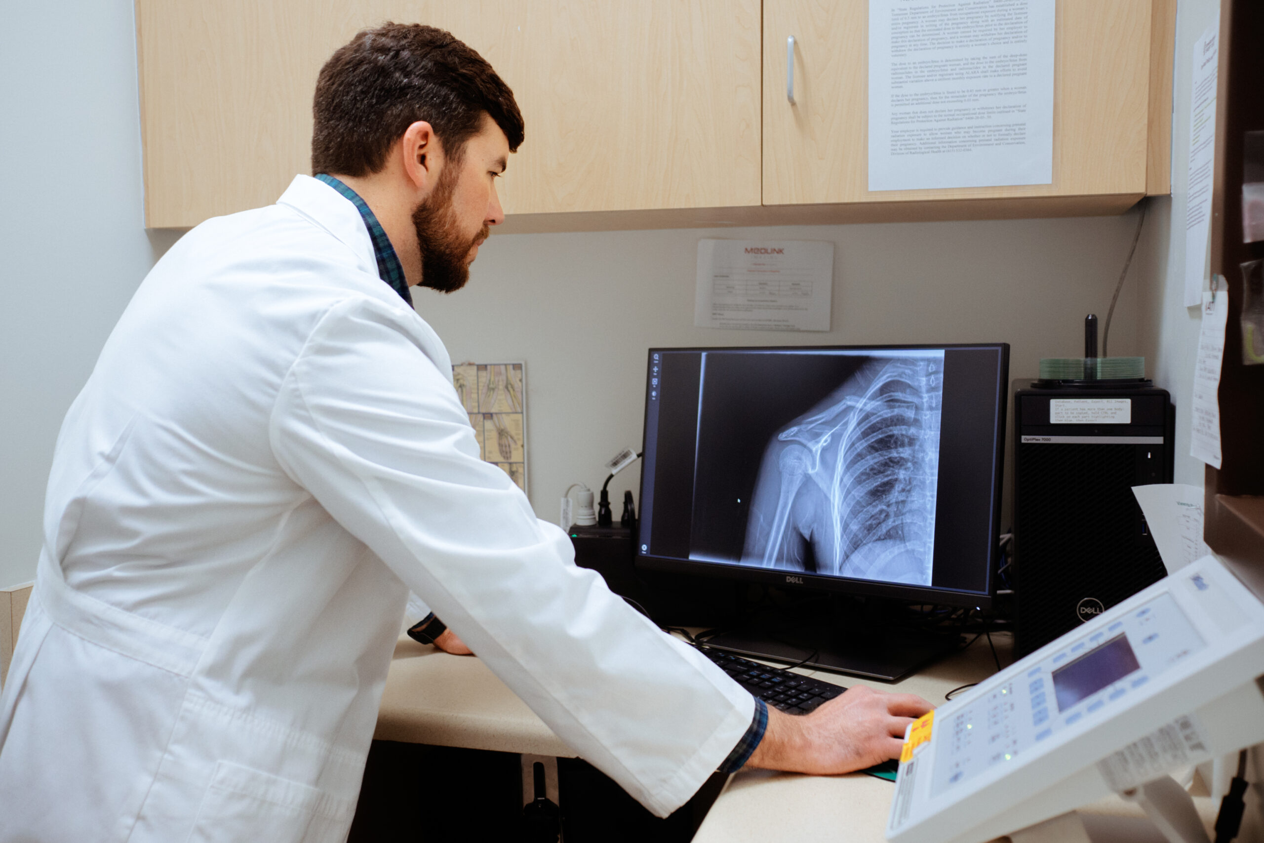 AFC medical professional examining a front-facing shoulder or humerus x-ray of a patient. AFC medical professional examining a front-facing shoulder or humerus x-ray of a patient.